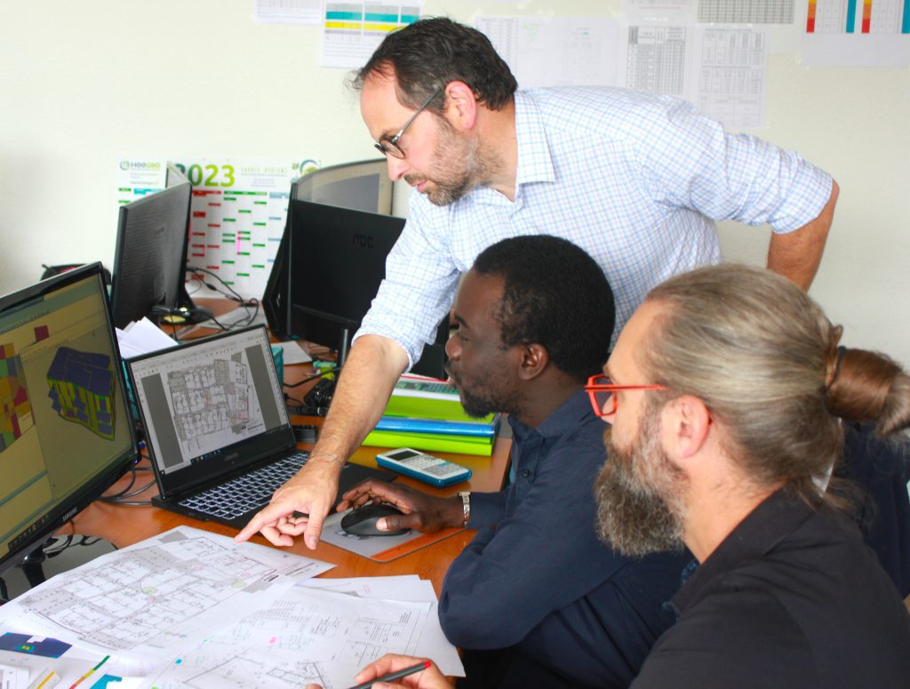 membres du bureau d'études XStructures regardant un plan et un ordinateur.
